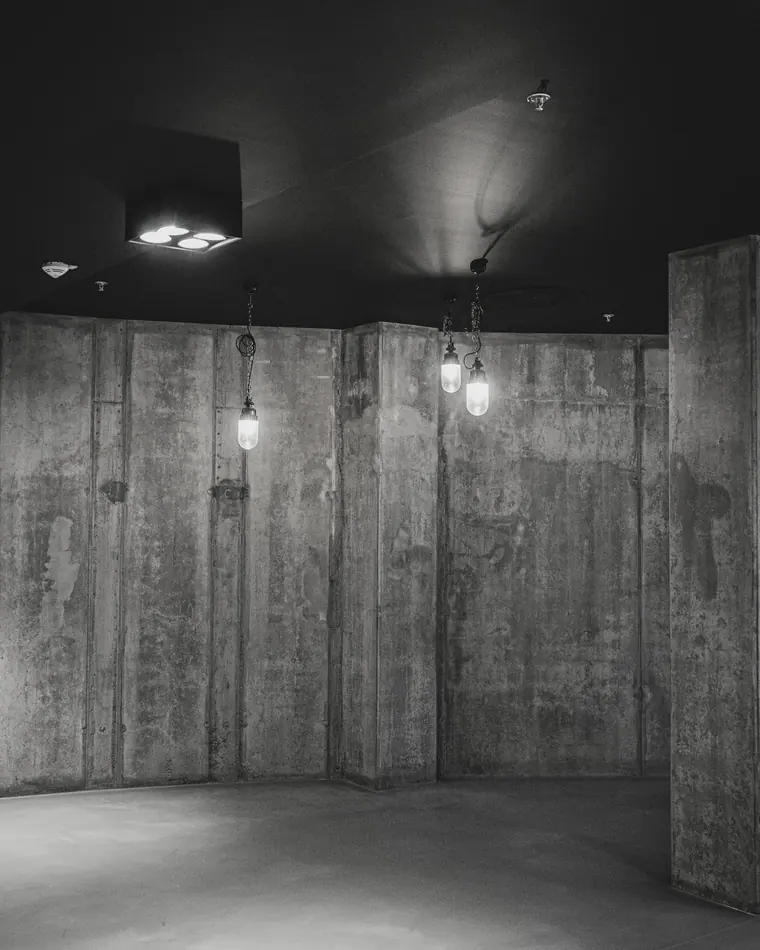 Interior com paredes de concreto aparente marcadas pelas juntas das fôrmas.